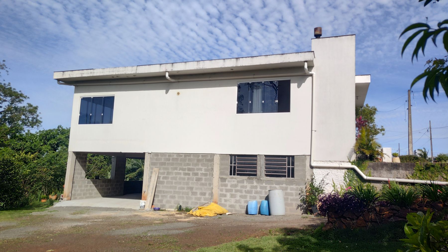 Os fundos, com a garagem e a churrasqueira tipo parrilha no térreo